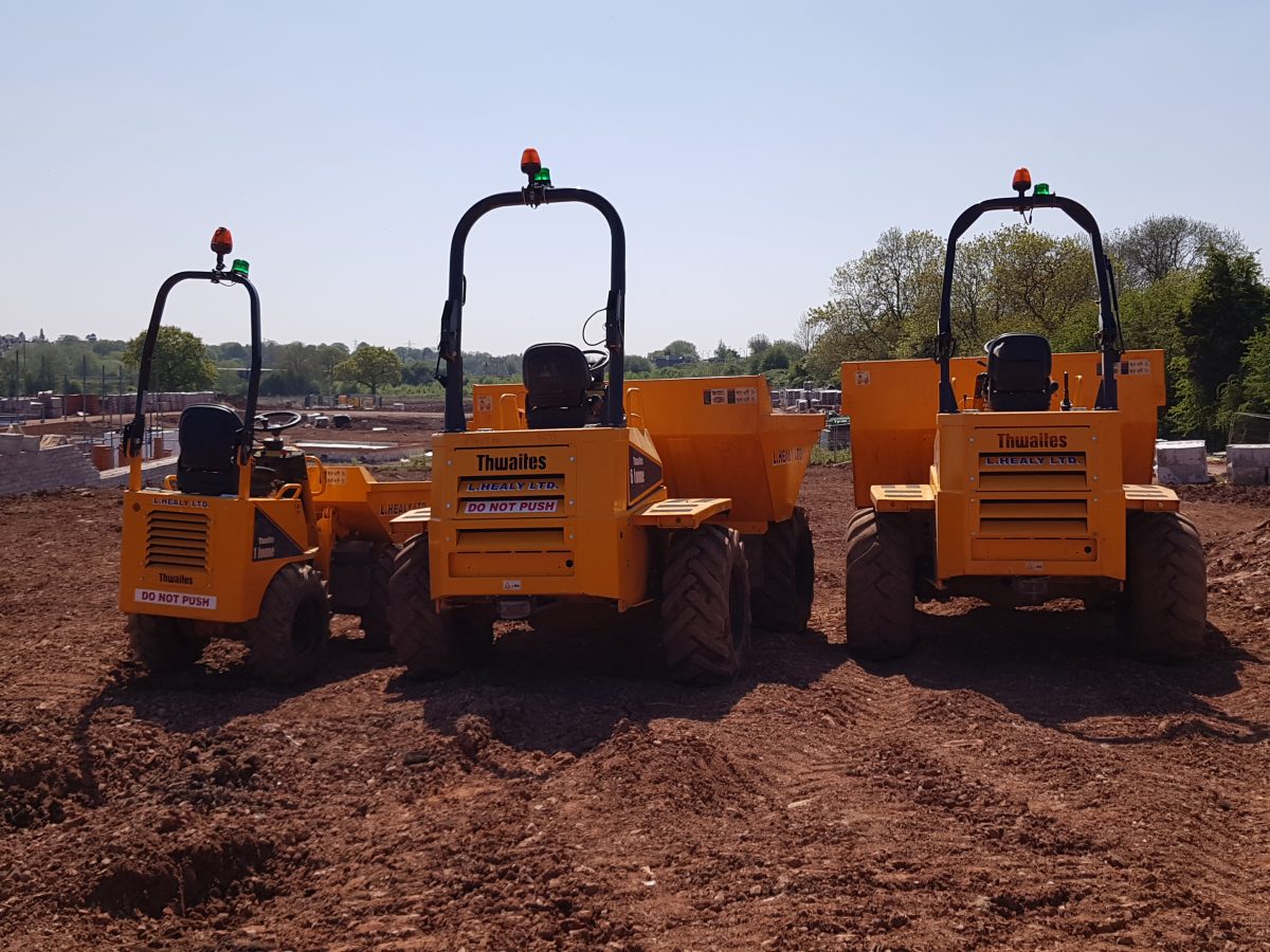 Rear view of three various sized L. Healy Ltd. Thwaites Dumpers